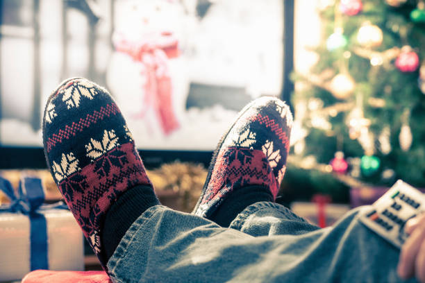 istock Watching television in Christmas slippers 2154232046