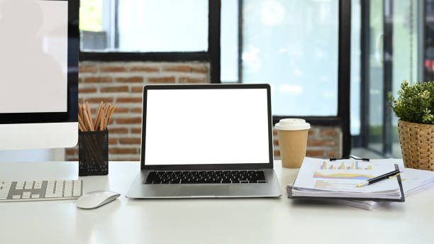 istock Front view laptop, financial document, coffee cup and stationery on white table 2154234742