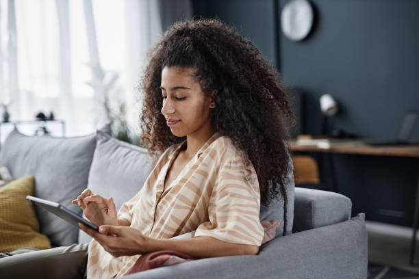 istock Young Woman Surfing Internet On Digital Tablet 2154236596