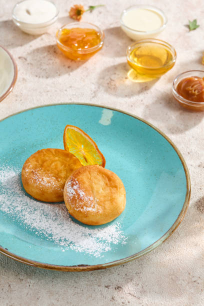 Delicious Syrniki with Citrus Garnish Served with Coffee on Rustic Table