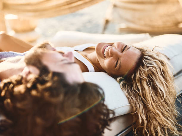 istock Cheerful couple communicating on a beach bed in summer day. 2154238282