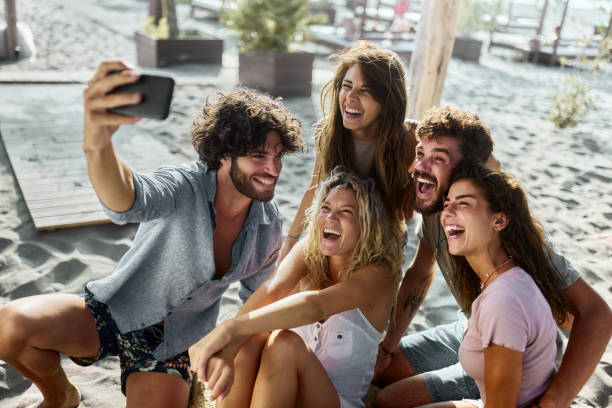 istock Happy friends taking a selfie with cell phone on the beach. 2154238404