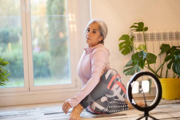 istock Senior Woman Doing Yoga at Home with Ring Light 2154238987