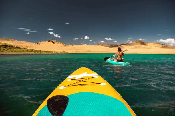 Girl walks on sup board in tropical lagoon