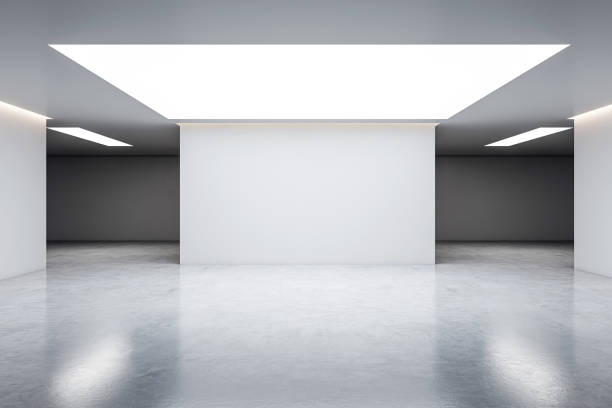 istock An empty modern gallery room with blank walls and a high ceiling with skylights, on a grey background, concept of a contemporary art space. 3D Rendering 2154242102