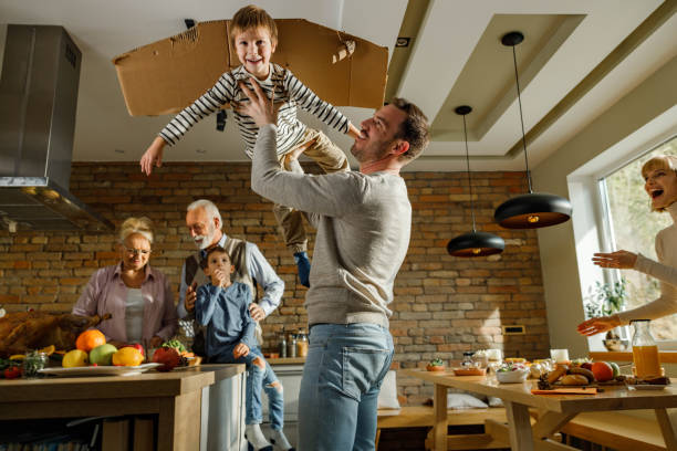 istock Playful father and son having fun during Thanksgiving day at grandparents' kitchen. 2154243043