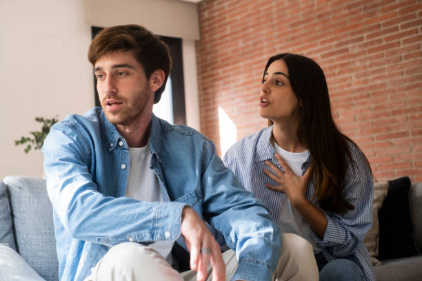 istock Close-up of a young couple sitting apart discussing having relationship problems, thinking about breakup or divorce. Family lovers, distraught men and women, avoid talking and suffer from betrayal in relationship problems. 2154244063