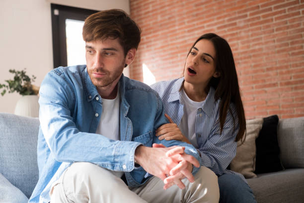 istock Close-up of a young couple sitting apart discussing having relationship problems, thinking about breakup or divorce. Family lovers, distraught men and women, avoid talking and suffer from betrayal in relationship problems. 2154244170