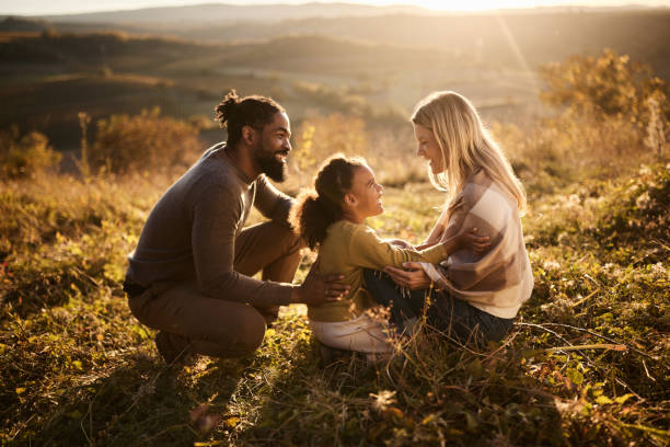 Happy diverse family talking while spending an autumn day in nature.
