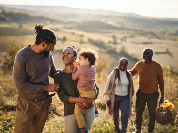 istock Happy black family talking while going on a picnic up the hill. 2154244422