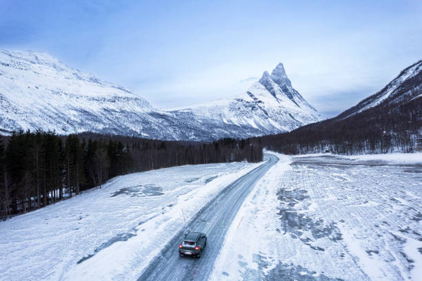 Car travelling mountain road, Norway Car driving empty road on mountain pass at dusk, Otertinden, Lyngen Alps, Troms, Norway, Scandinavia, Europe road into norwegian snow mountains and clouds heaven nordic countries stock pictures, royalty-free photos & images