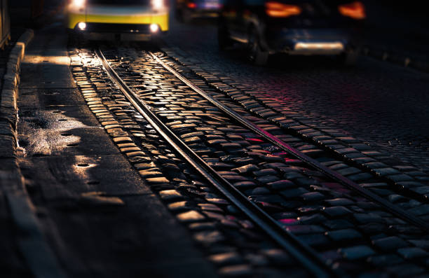 A tram glides through the misty Warsaw night, its motion captured as golden light streaks. The fog, streetlights, and blurred movement create a dreamlike urban atmosphere.