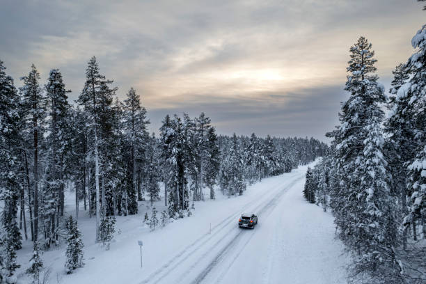 Car crossing snowy forest in winter, Finland