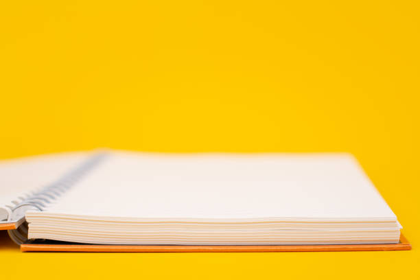 Orange book on yellow educational background White paper for studying and taking notes.