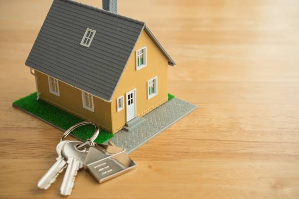 istock House model and key on wooden table background with copy space. 2154249662