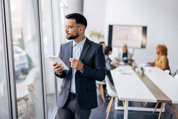 istock Focused businessman with tablet in glass office 2154250631