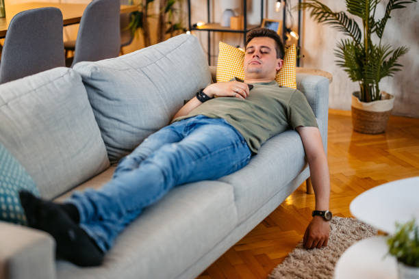 istock Young Man Sleeping On The Sofa At Home 2154251527