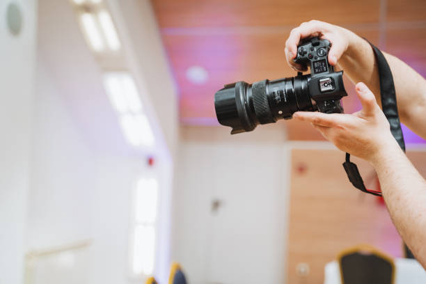istock Person holding a digital camera with their fingers on the camera lens 2154252892