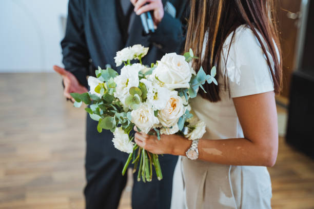 istock A man with a microphone and a woman with white flower bouquet 2154252929