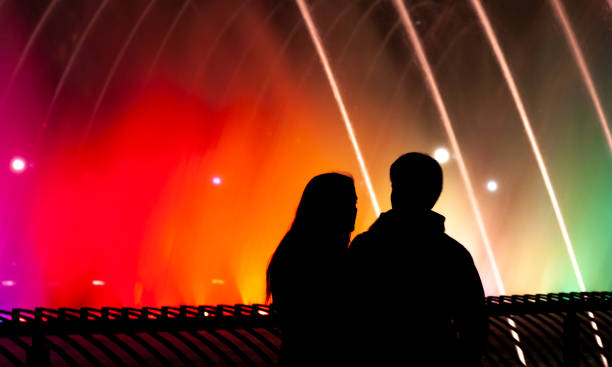 Santiago de Chile, Chile - May 14, 2017: An unknown couple taking a walk around the water light fountain in Providencia neighborhood at night, Santiago de Chile, Chile, Latin America.