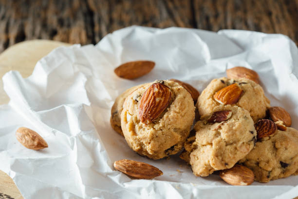 Integral biscuits with sliced almonds on a pile closeup isolated on white. Healthy snack and dessert