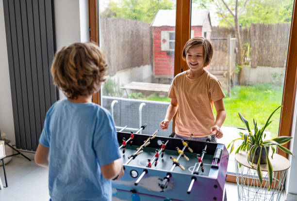 istock Two boys play table football at home 2154261951