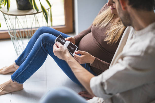 istock Couple expecting a baby looking at pregnancy ultrasound scan 2154262007
