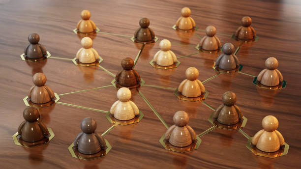 Diverse wooden figurines are connected in a network formation, illustrating relationships and connections on a wooden background during the day. Communication Concept.