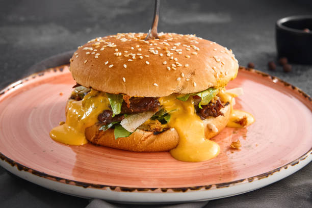 istock A succulent pulled beef burger dripping with rich cheese sauce, served on a plate for a mouthwatering meal 2154265865
