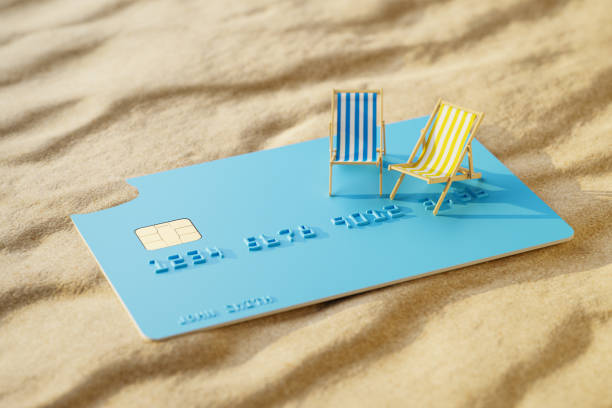 istock Using a credit card for paying the summer vacation concept. Two beach folding chairs on an oversized credit card on the beach 2154266283
