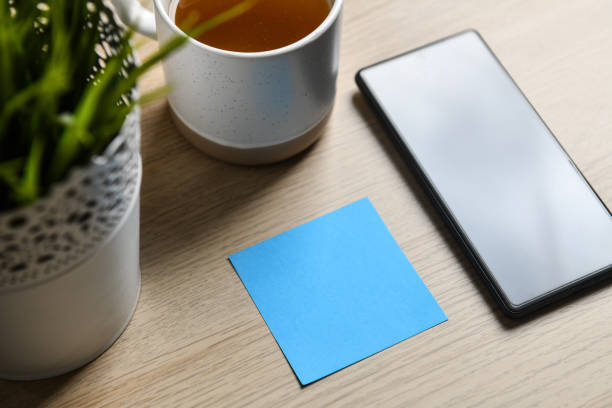 Modern Tools for Work and Reminiscence - A Blue Sticky Note, A Cup Of Tea and Smartphone