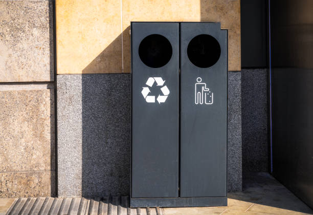 Close up view of human hand throwing an empty plastic bottle into the trash can. Environment care concept, ecological lifestyle, garbage recycle bin, trash sorting
