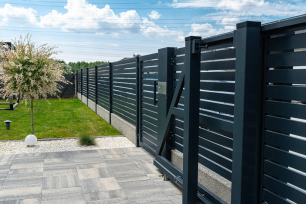 istock A modern panel fence in anthracite color, a visible sliding gate to the garage and a wicket with a letterbox. 2154281277