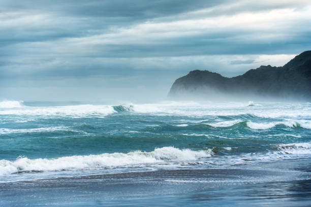 Moody sea with breaking wave on coastline in West of Auckland at New Zealand