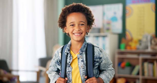 istock Smile, face and student in classroom for education, learning and ready for morning kindergarten. Happy, school and portrait of boy or child with knowledge, studying and pride for academic lesson 2154290463