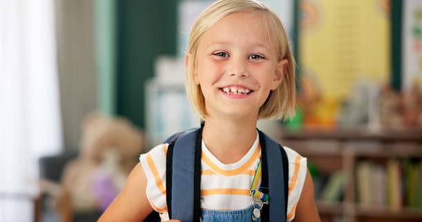 Happy, face and child in classroom for education, learning and ready for morning kindergarten. Smile, school and portrait of girl or student with knowledge, studying and pride for academic lesson