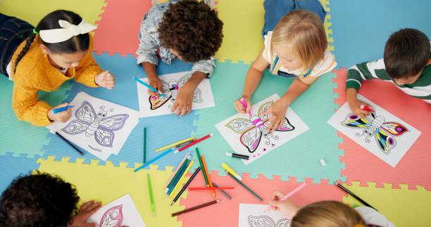 istock Children, group and drawing for creative learning in classroom for education, project or back to school. Boys, girls and friends on floor mat for student art lesson or Montessori, youth or playing 2154290506