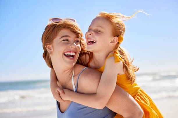 istock Mother and daughter having fun at beach 2154294010