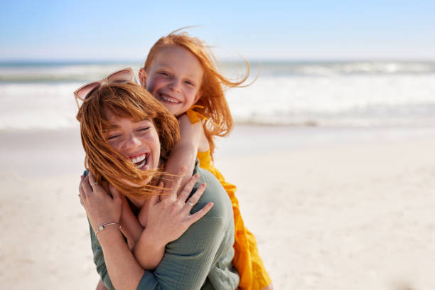 joyful young mother smiling with little daughter at beach - dotter bildbanksfoton och bilder