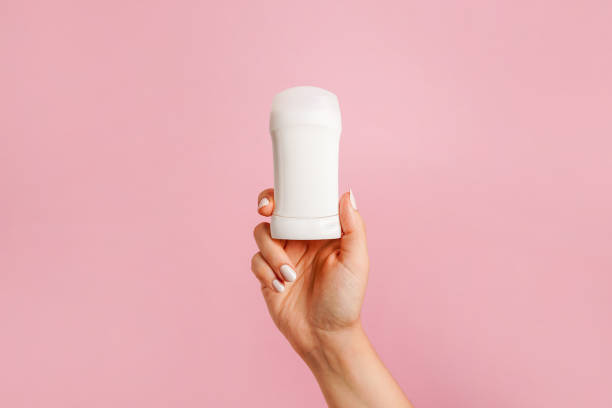 istock Hand holding white body deodorant on pink background 2154296225