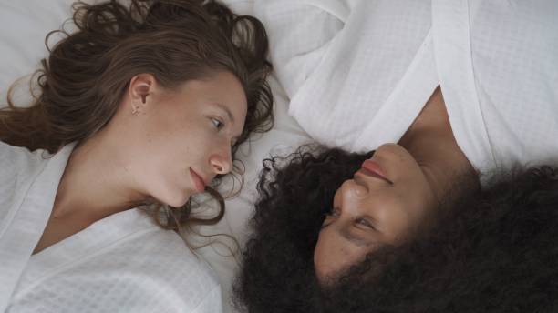 istock Two female friends having smile with good feeling on white bed 2154297904