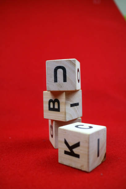 Educational stacking cube toy made of wood with numbers and letters. Red background