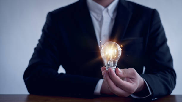 istock Idea innovation and inspiration concept.Hand of man holding illuminated light bulb, Idea innovation and inspiration concept.  creativity with bulbs that shine glitter, Concept for success. 2154310712