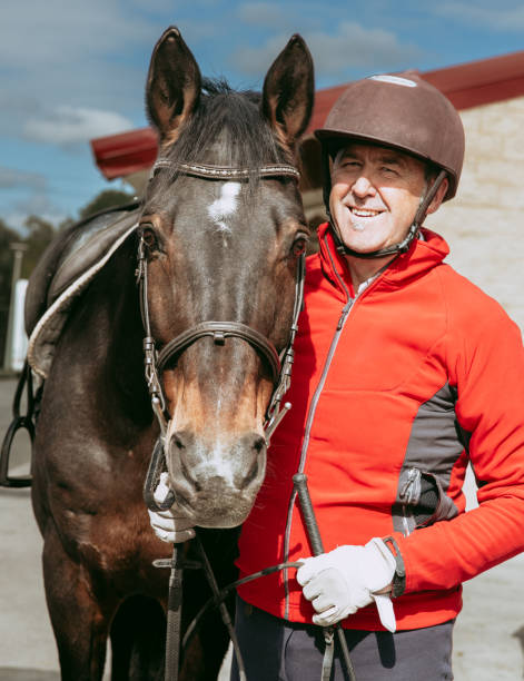 istock Smiling senior man with horse before riding 2154313968