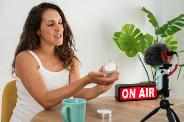 istock Female vlogger demonstrating beauty product on camera 2154316710