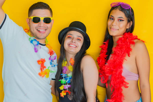 istock three young multiethnics, smiling and posing happily, dressed in carnival clothes, on a yellow background. 2154316979