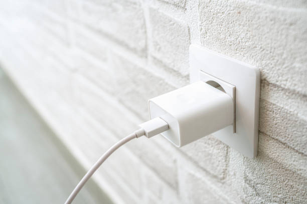 istock Close up of phone battery charger plugged in wall socket 2154324986