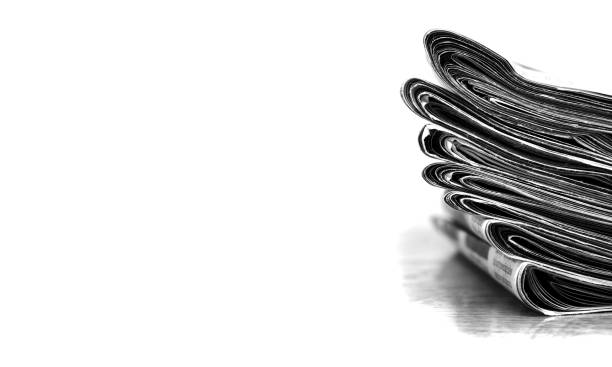 Piled up newspaper isolated on white background with latest breaking news communication in writing
