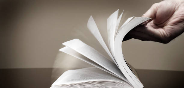 istock Book and Hand Flipping Pages Information Reading Searching and Learning 2154327433