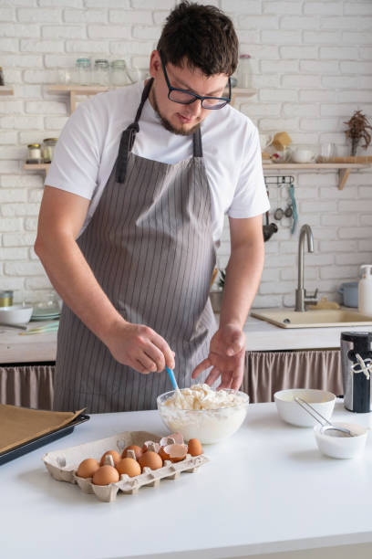 istock man wearing apron cooking tiramisu at kitchen 2154331034